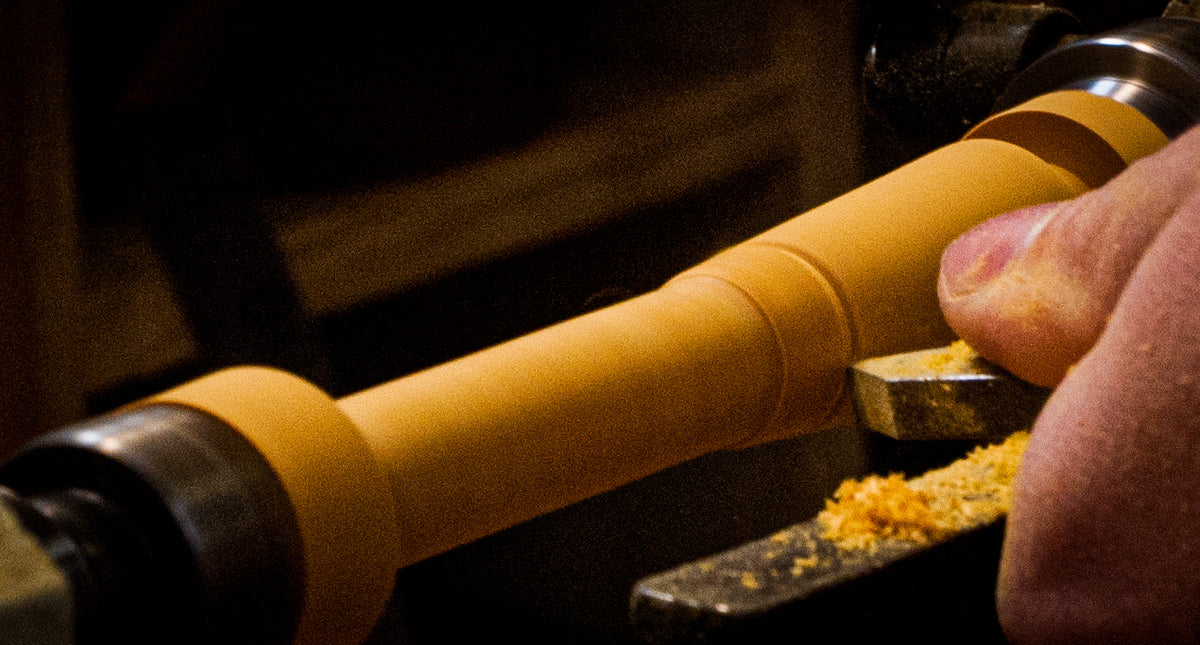 Shaping a wooden duck call insert by hand on the lathe
