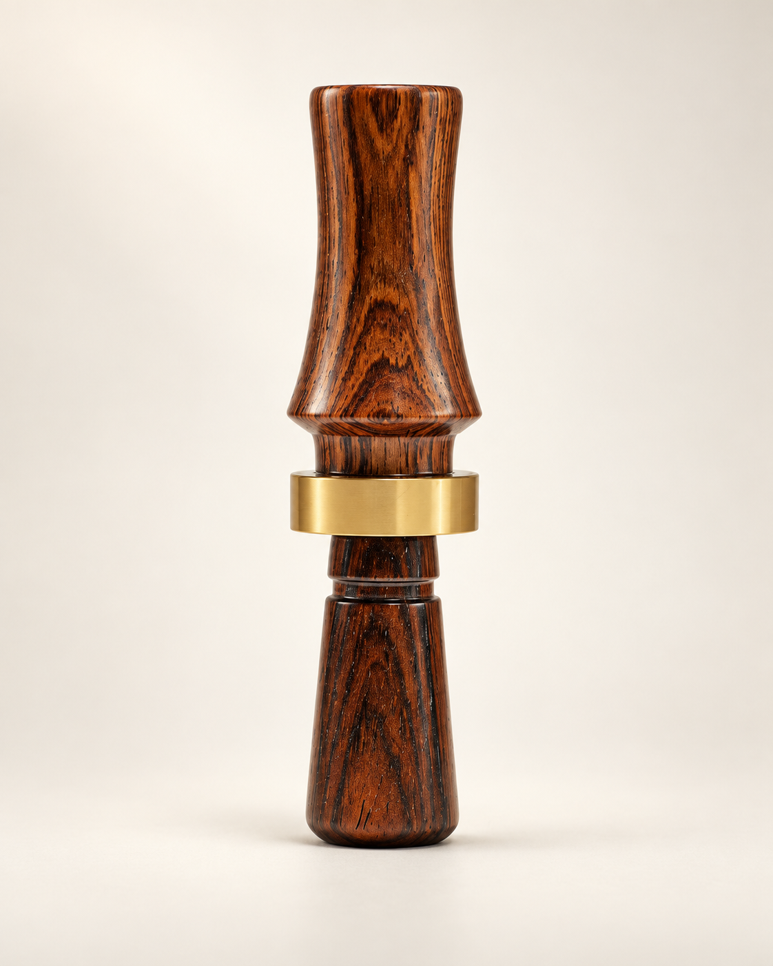 Studio portrait of a wooden Longleaf duck call with a brass band